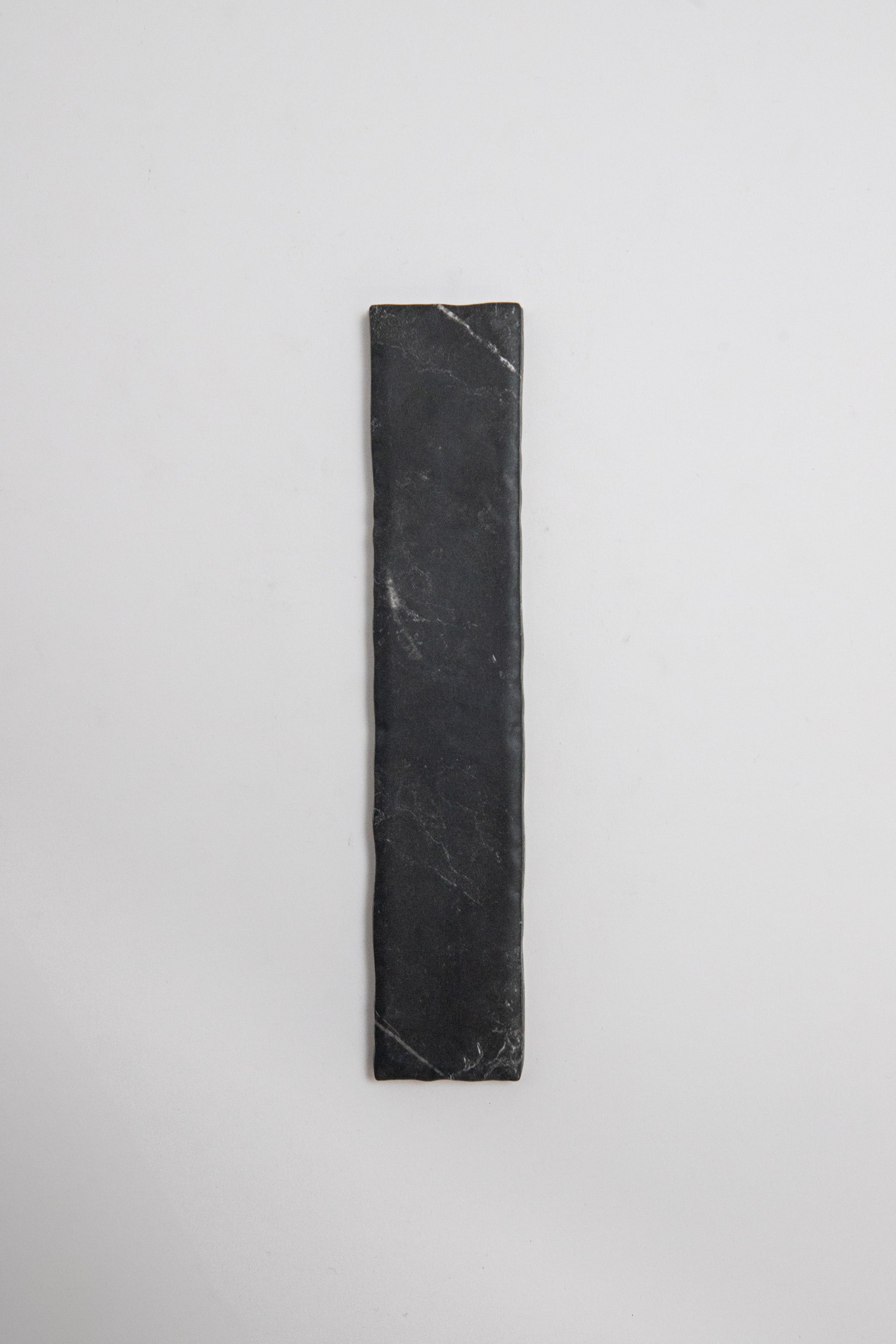 A Tosca Black Marble, Extra Sample, is placed vertically on a plain white background.