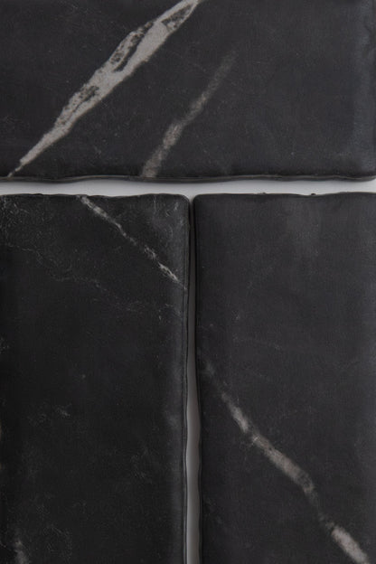 Four Tosca Black Marble, Extra Sample tiles with white veining, arranged in a grid with thin gaps between them.
