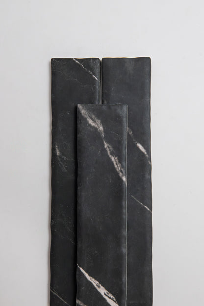 Three Tosca 'Black Marble, Extra Sample' tiles with white veining, arranged vertically on a light background.