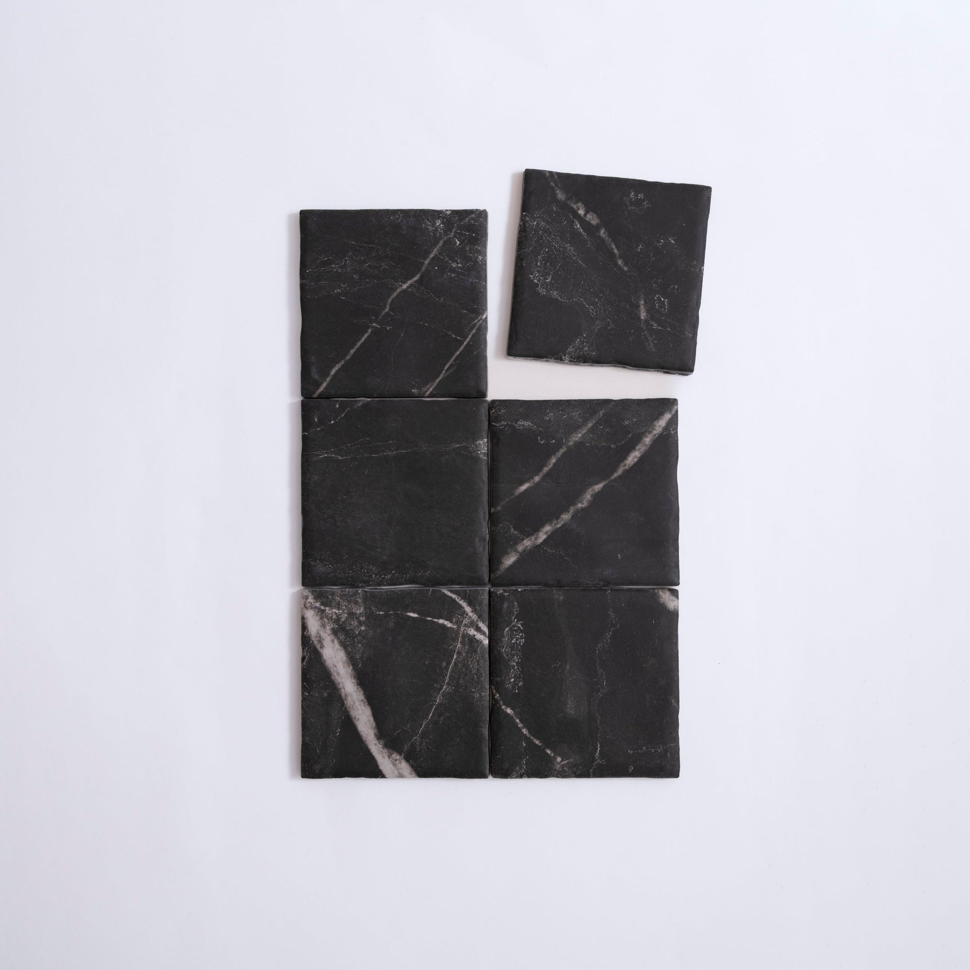 Six Tosca Black Marble, Extra Sample tiles in a grid; the top right tile is slightly offset upward.