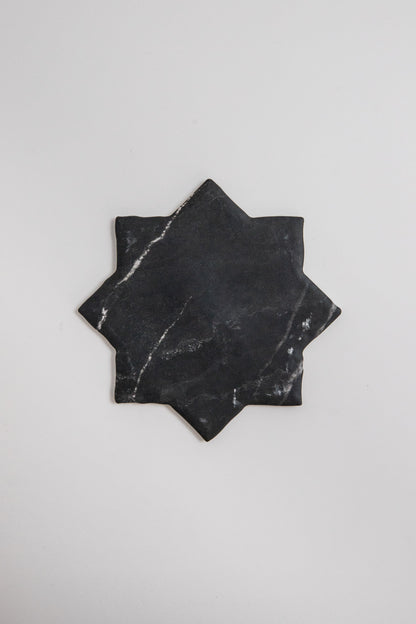Tosca Black Marble, Extra Sample—star-shaped tile with white marbling on a plain white background.