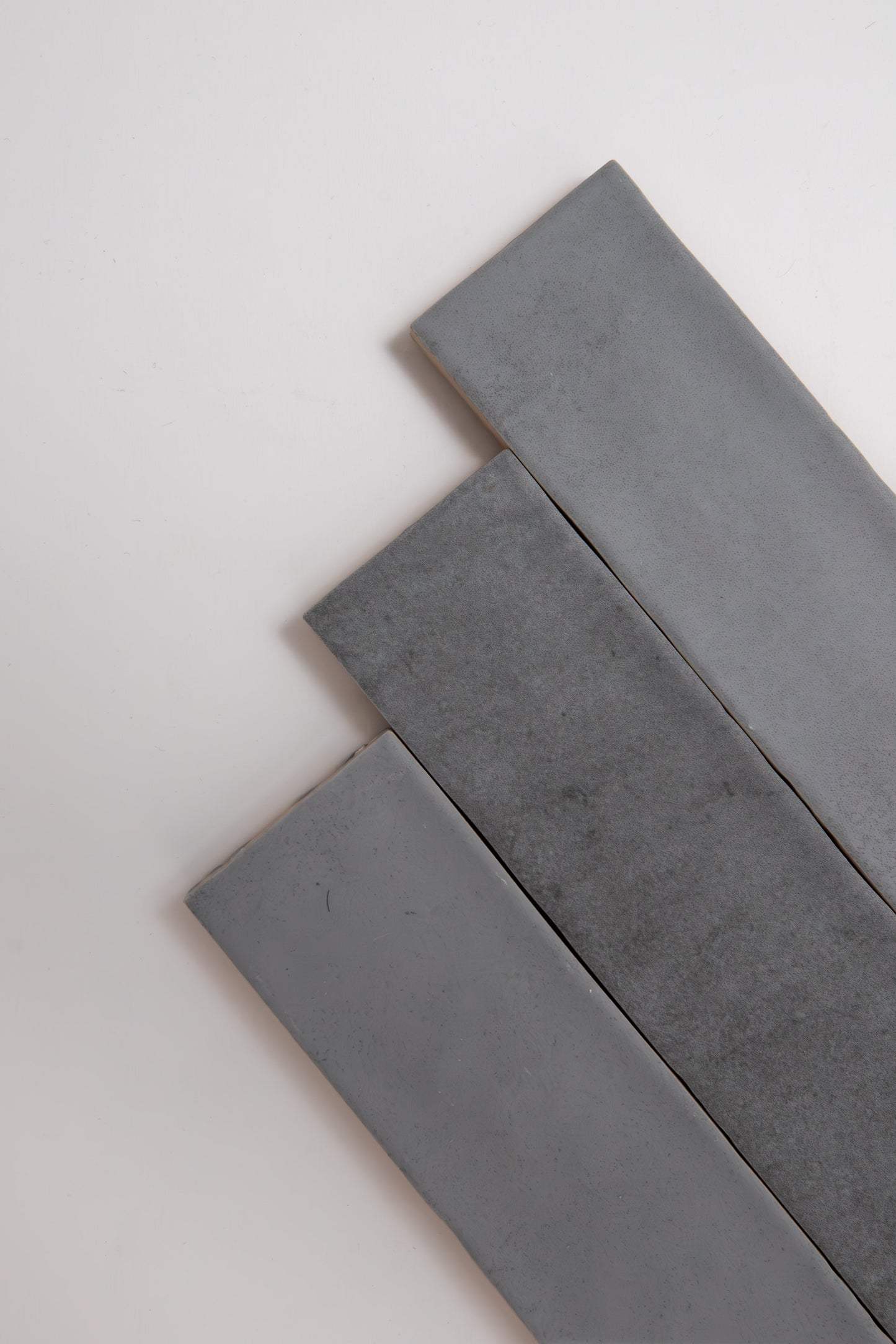 Four Bourton Dark Blue tiles by Cottage Ivy arranged diagonally on a white background.