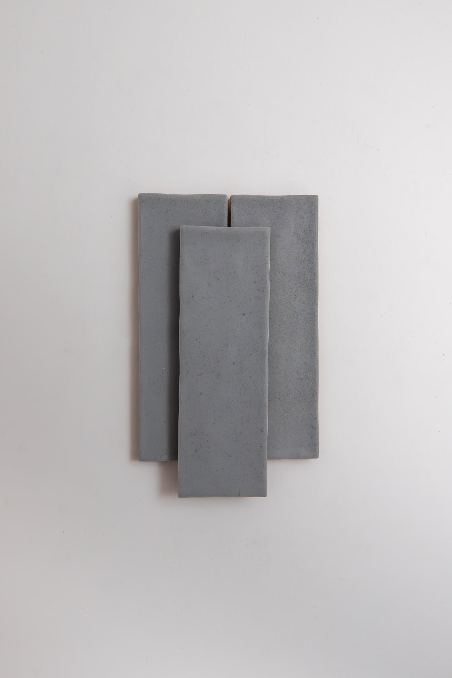 Three Bourton Dark Blue tiles by Cottage Ivy are stacked vertically, overlapping on a plain white background.