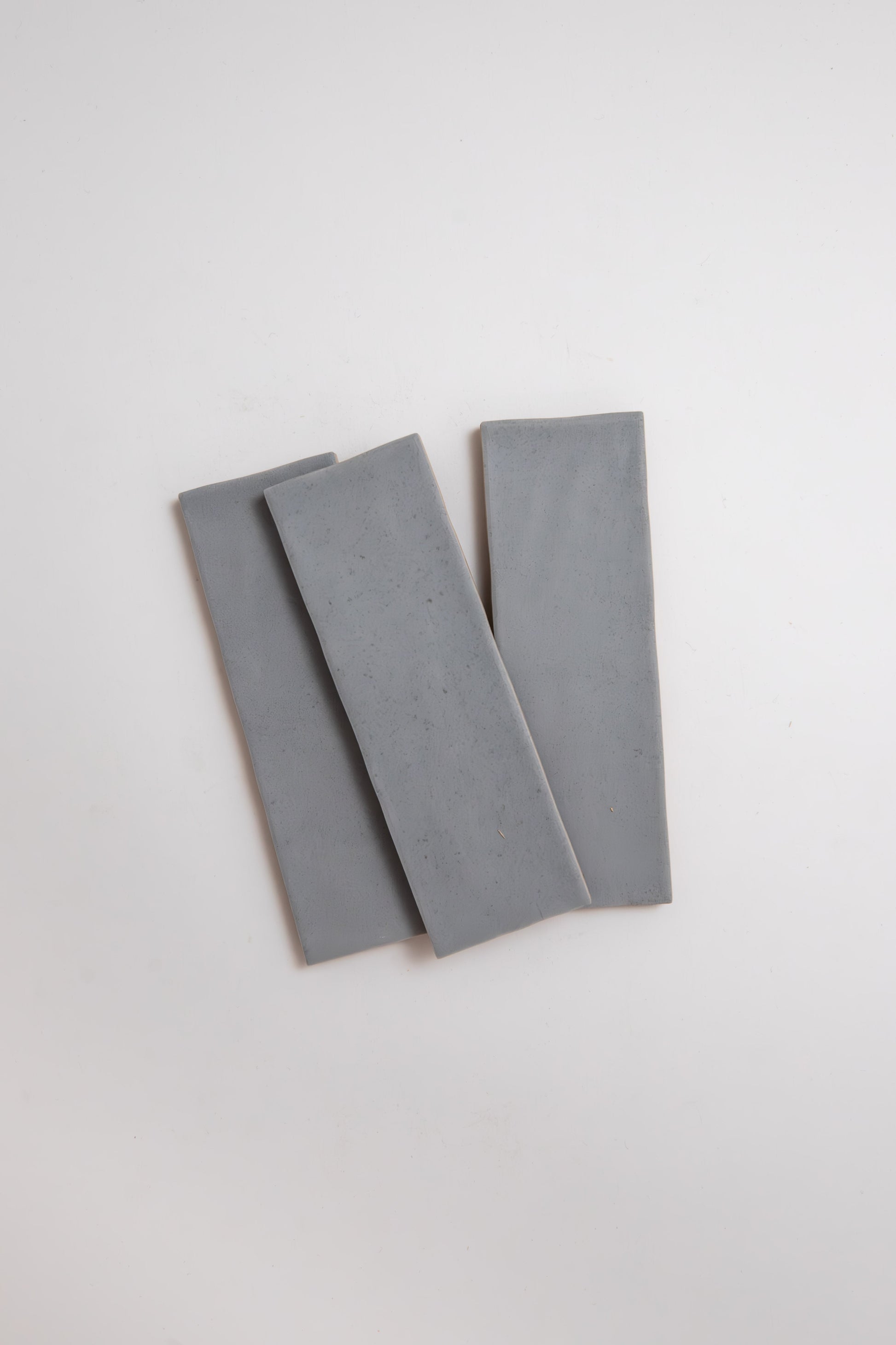 Three rectangular Bourton Dark Blue ceramic tiles by Cottage Ivy, arranged overlapping on a white background.