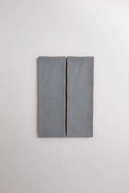 Two rectangular Bourton Dark Blue tiles by Cottage Ivy are mounted side by side on a white wall with a narrow gap.