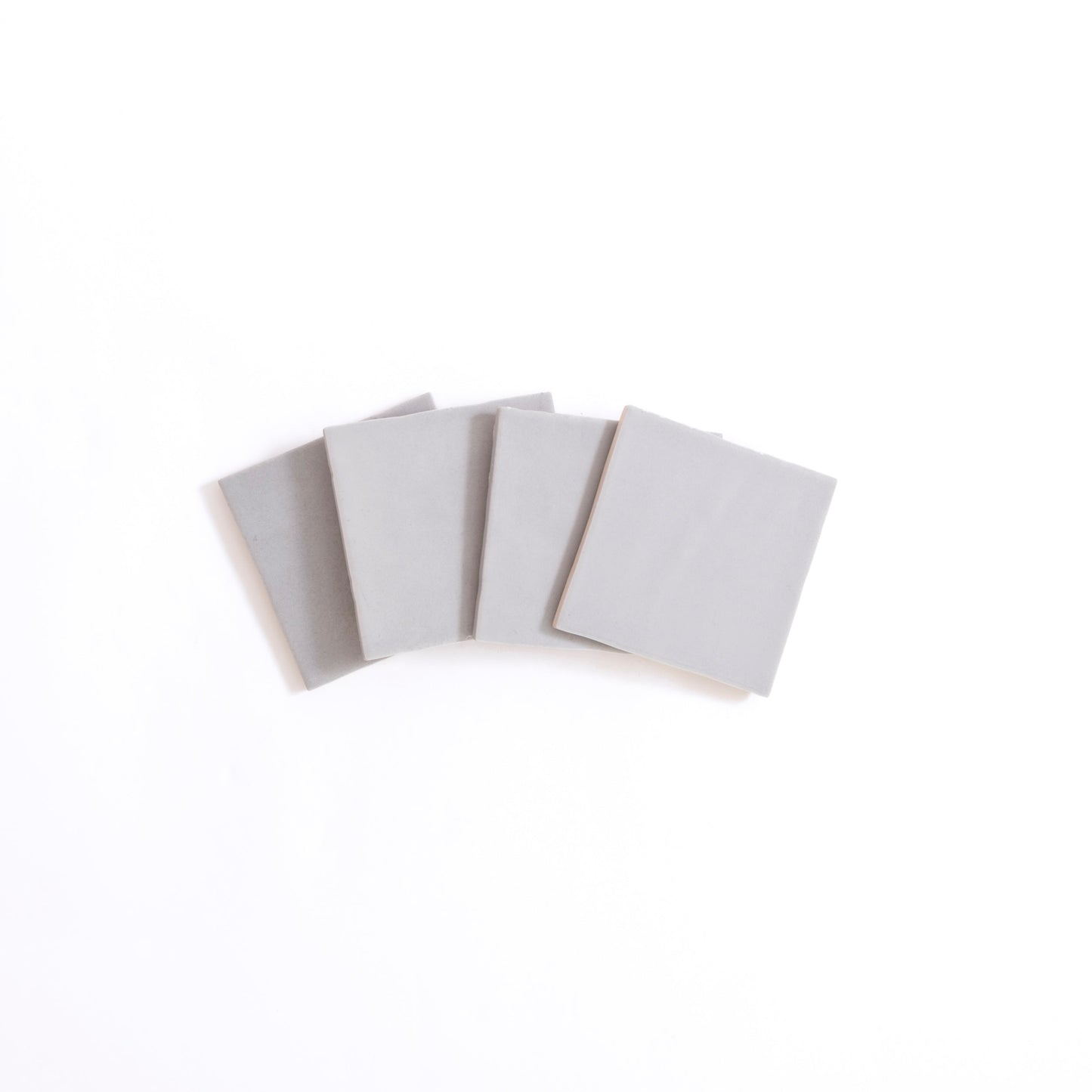 Four Bourton Dark Blue square tiles by Cottage Ivy are arranged in a slight fan shape on a white background.