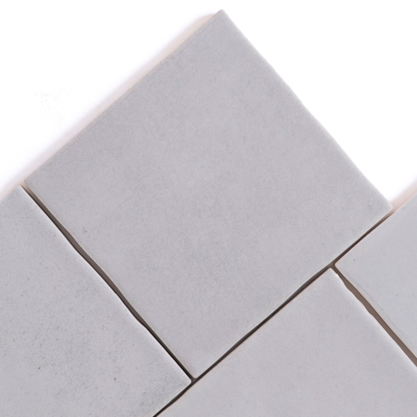 Four Bourton Dark Blue square tiles by Cottage Ivy, arranged diagonally with small gaps on a white background.