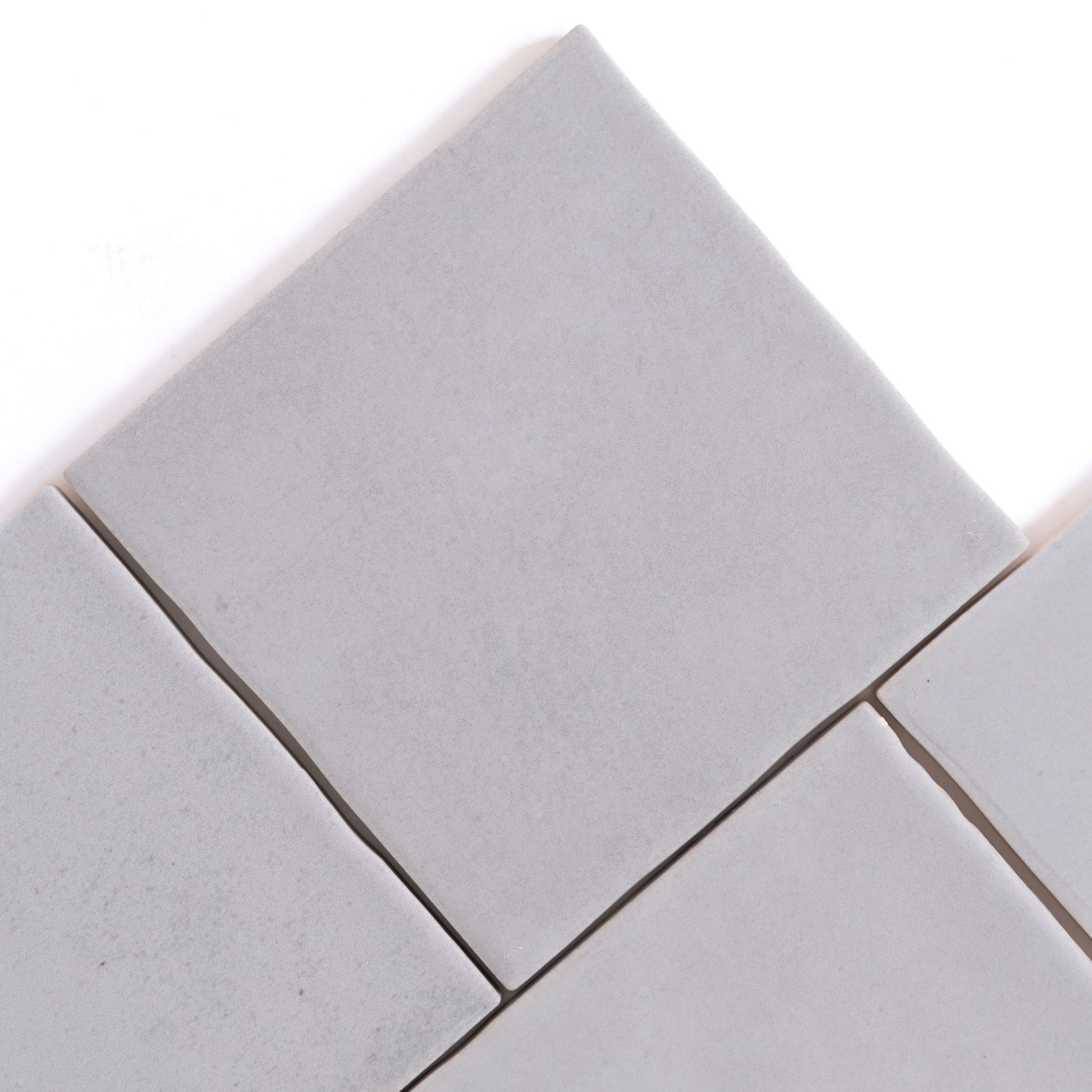 Four Bourton Dark Blue square tiles by Cottage Ivy, arranged diagonally with small gaps on a white background.