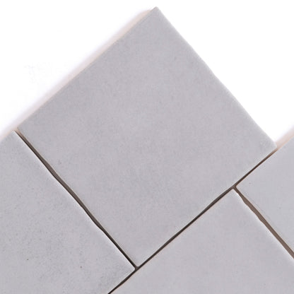 Four Bourton Dark Blue square tiles by Cottage Ivy, arranged diagonally with small gaps on a white background.