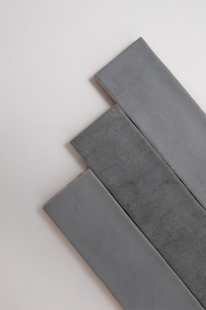 Three Bourton Dark Blue tiles by Cottage Ivy are arranged diagonally on a plain white background.