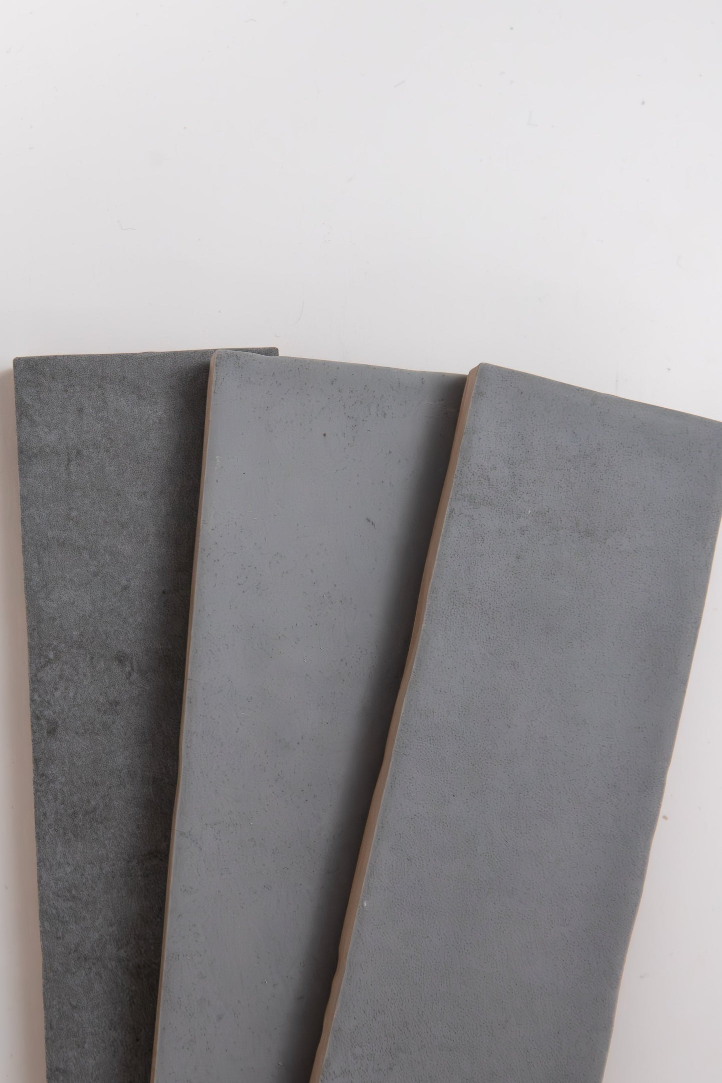 Three Bourton Dark Blue tiles by Cottage Ivy are arranged side by side on a white background.