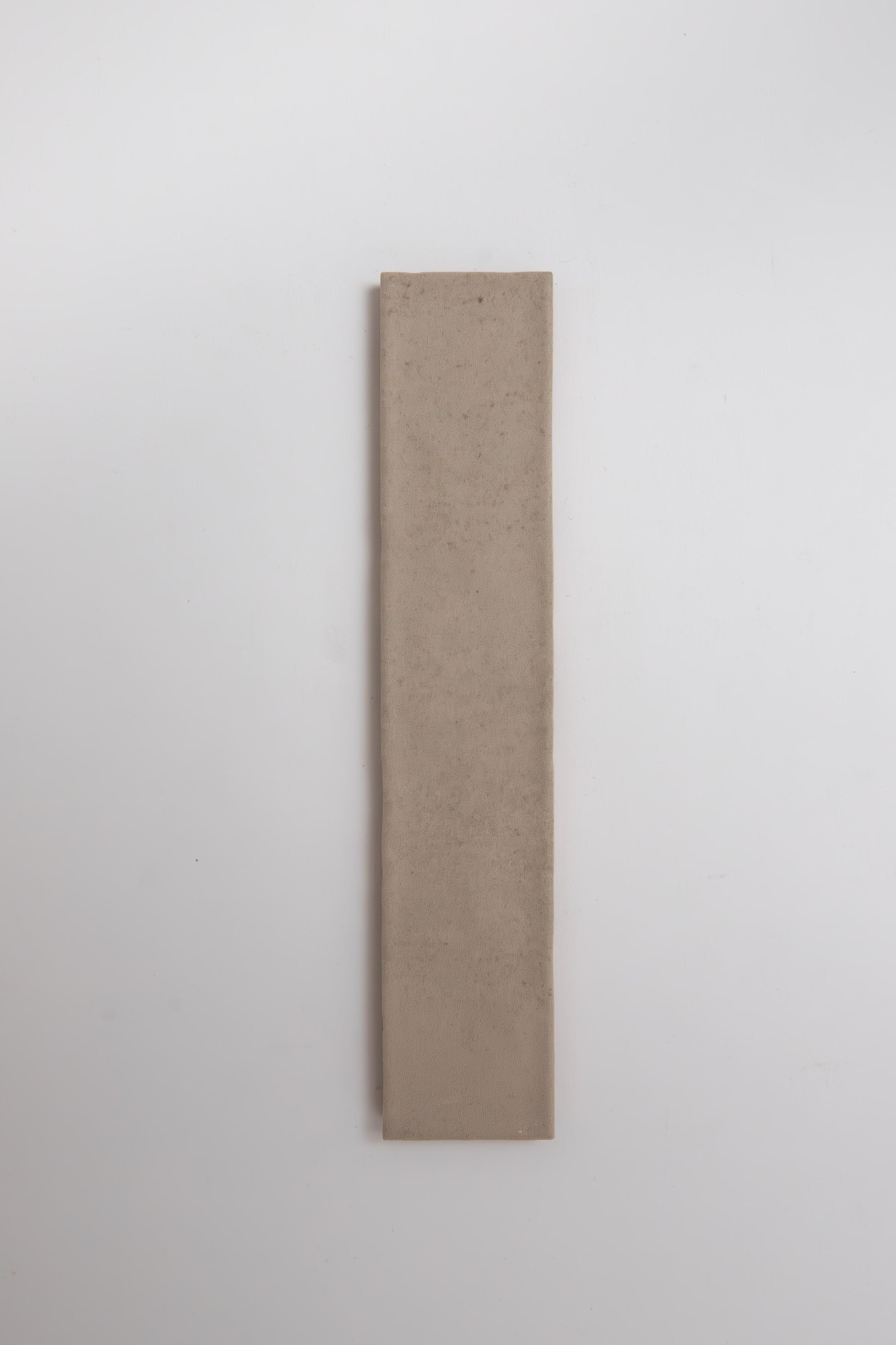 A single Buckland Beige tile sample by Cottage Ivy is placed vertically on a plain white background.