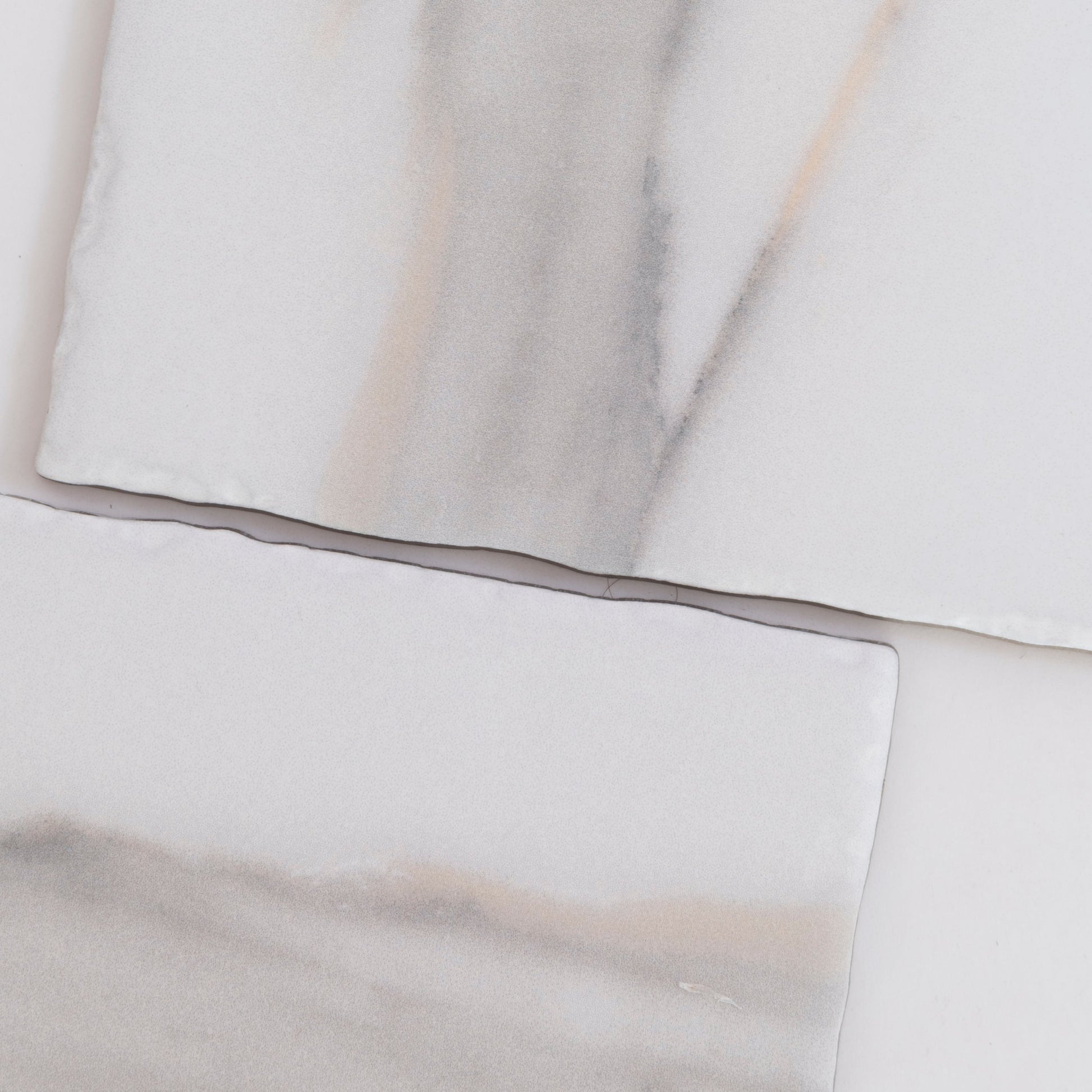 Two rectangular Tosca Calacatta Gold marble tiles with subtle gray and beige veining on a white background.