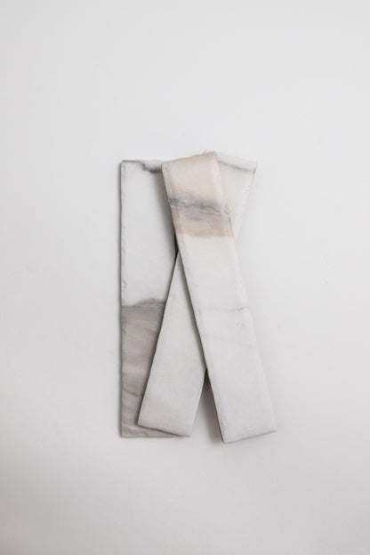 Two Tosca Calacatta Gold tiles are stacked in an X shape on a plain white background.