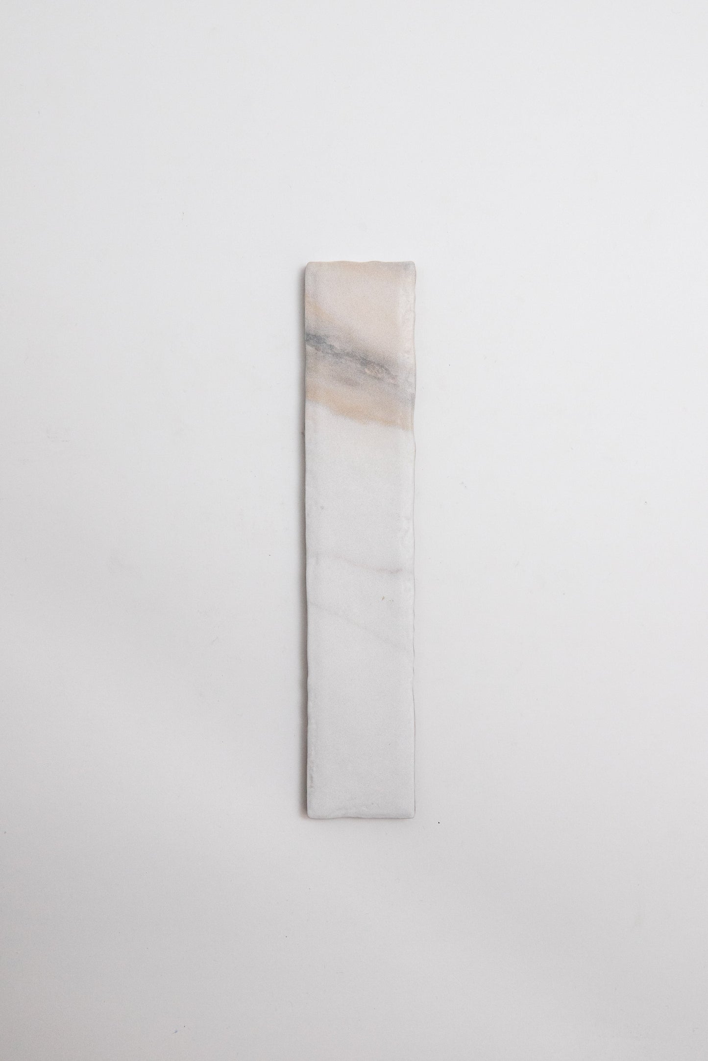Tosca Calacatta Gold: a rectangular white stone with subtle beige and gray veining on a plain background.