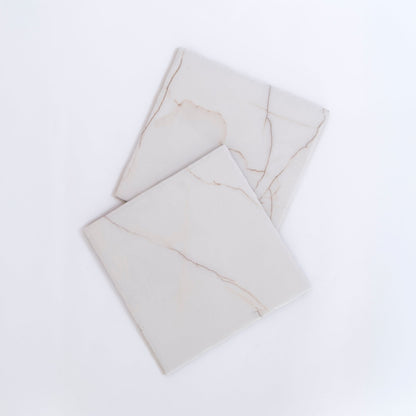 Two Calacatta Soft marble tile samples by Tosca, white with subtle beige veins, overlap on a white background.