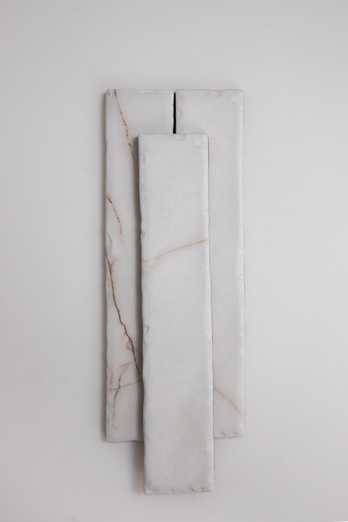 Three rectangular Tosca Calacatta Soft marble samples with subtle brown veins, stacked on a light background.