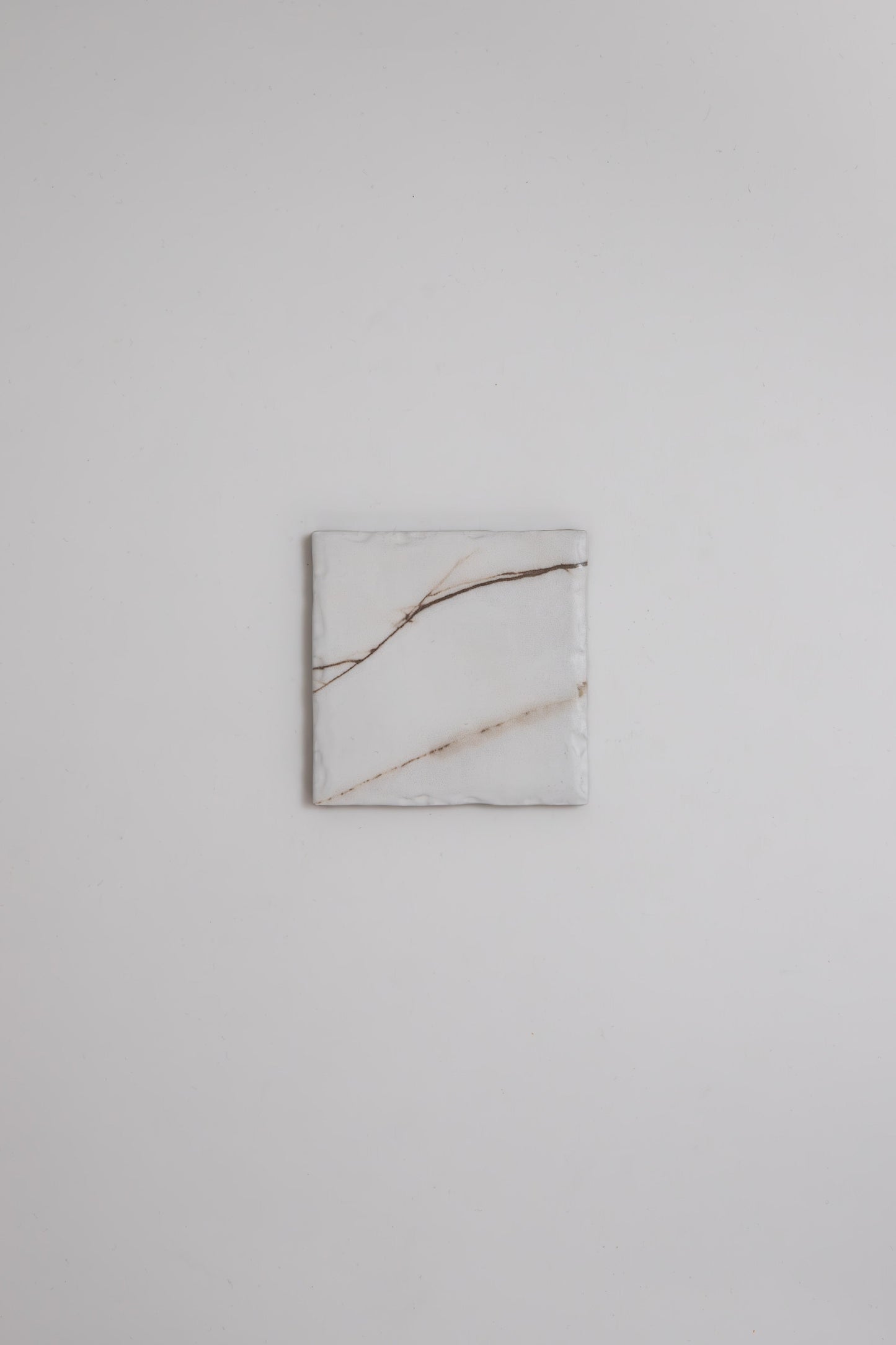 A square Calacatta Soft marble tile by Tosca with light brown veins, centered on a plain white background.
