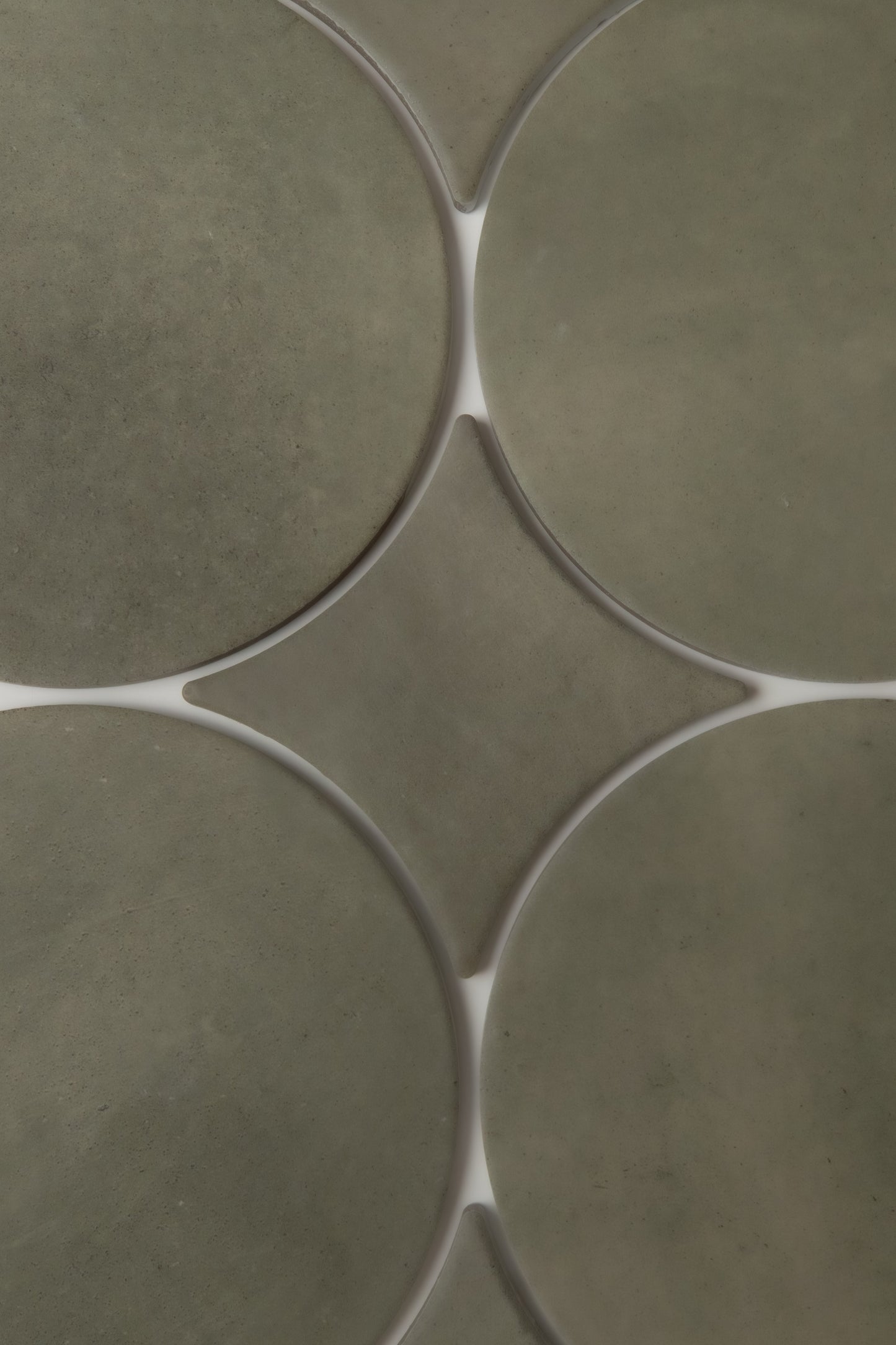 Close-up of Finca’s Cardon, Extra Sample: olive green curved tiles with white grout in a geometric pattern.