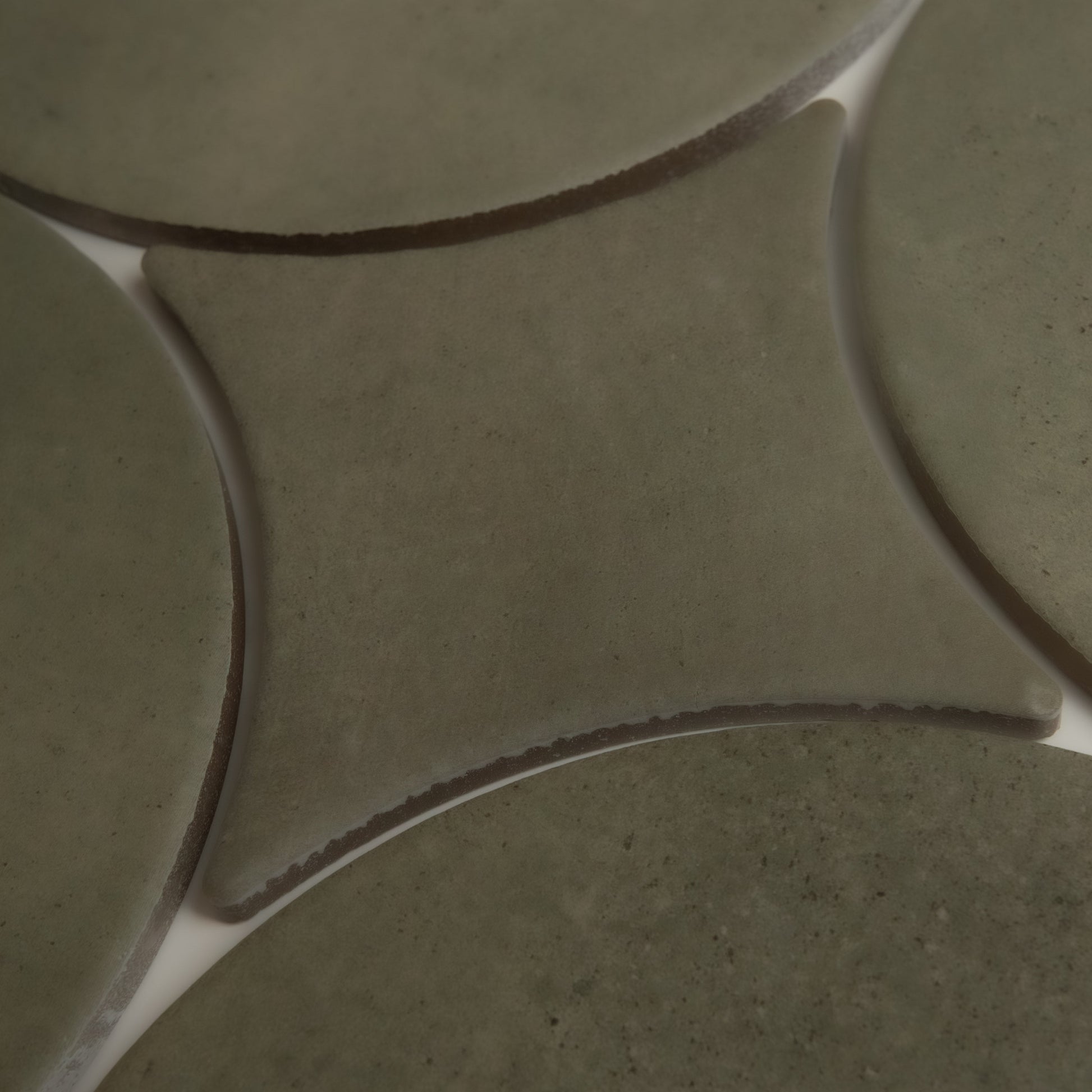 Close-up of Cardon, Extra Sample by Finca: greenish ceramic tiles with curved edges and white grout lines in a geometric pattern.