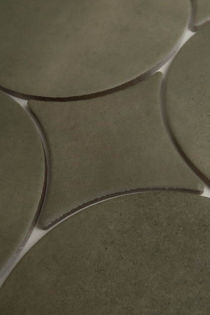 Close-up of Finca's Cardon Sample: greenish curved ceramic tiles with white grout forming star-like intersections.