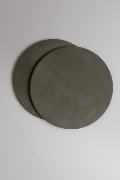 Two round, flat, gray Cardon samples by Finca overlap on a plain white surface.