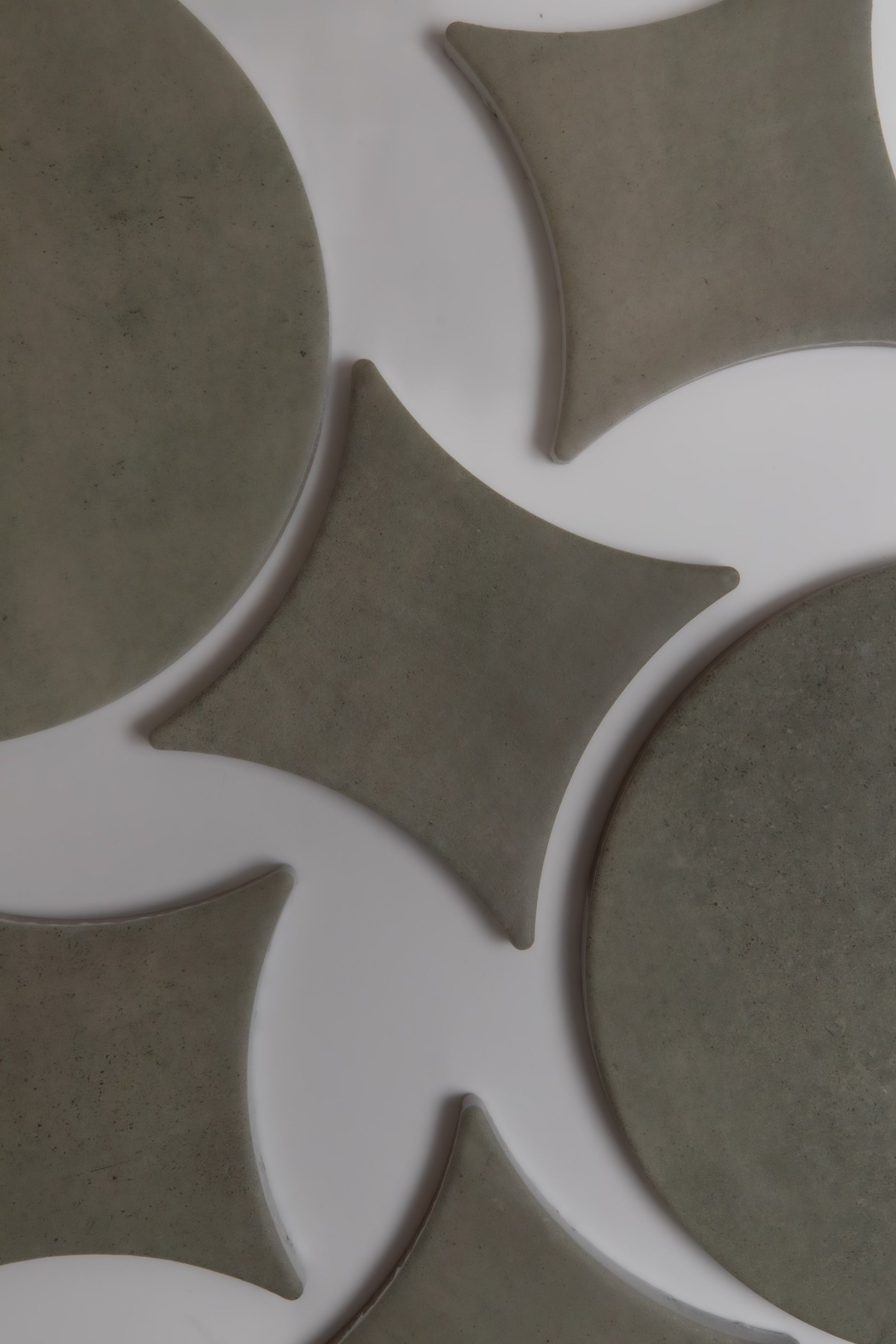 Finca Cardon Sample: Abstract gray round and diamond tiles on white, top view.