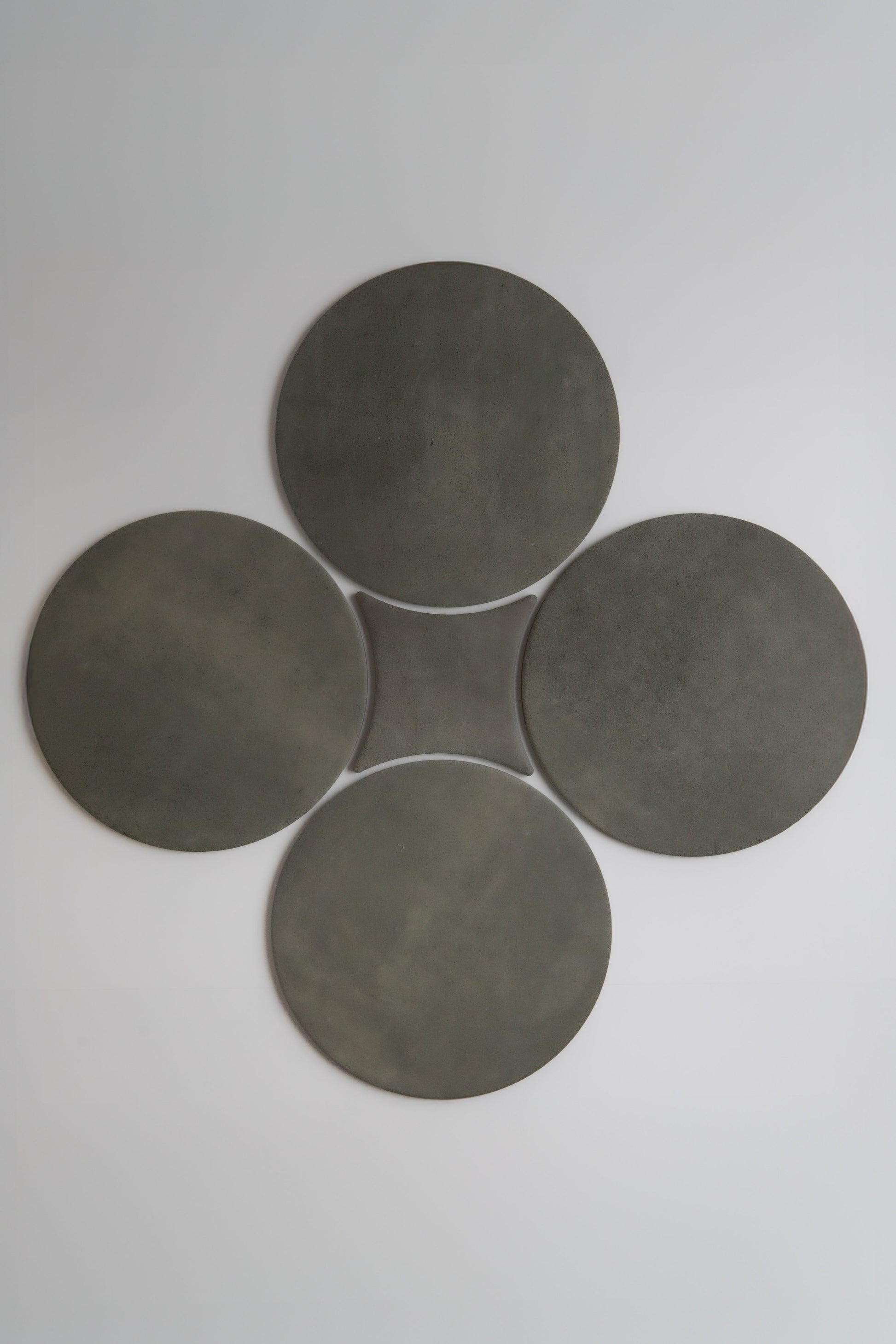 Four dark gray circles in a clover pattern on light backdrop. Product: Cardon, Sample by Finca.