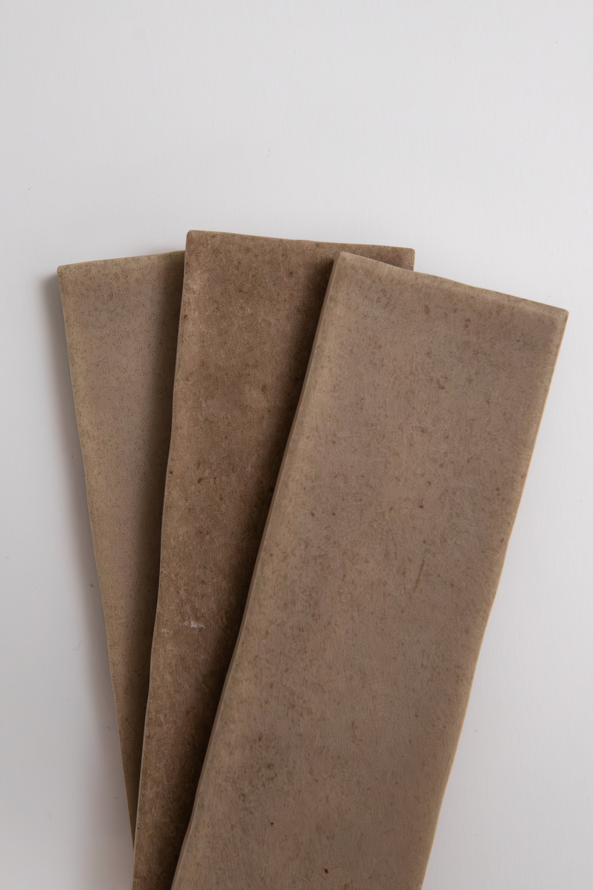 Three Castlegate Brown tiles by Cottage Ivy are arranged side by side on a white background.