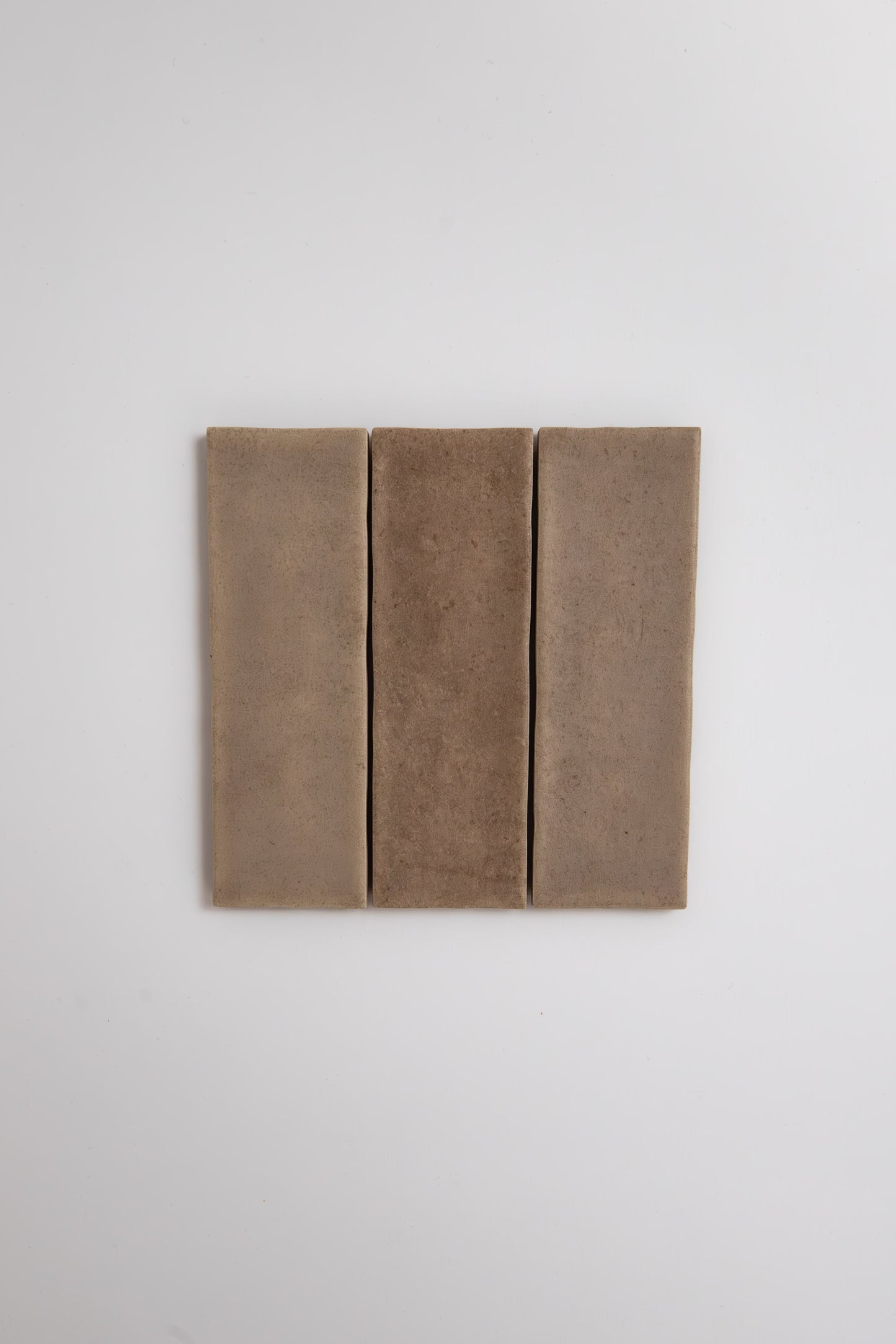 Three Castlegate Brown tiles by Cottage Ivy are arranged vertically side by side on a plain white background.