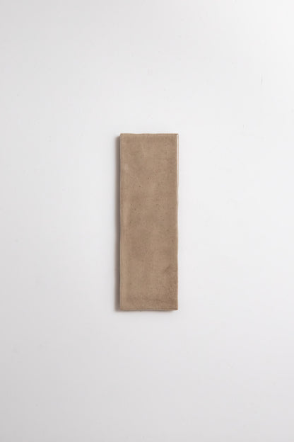 Castlegate Brown sample tile by Cottage Ivy, rectangular beige ceramic, centered on a plain white background.
