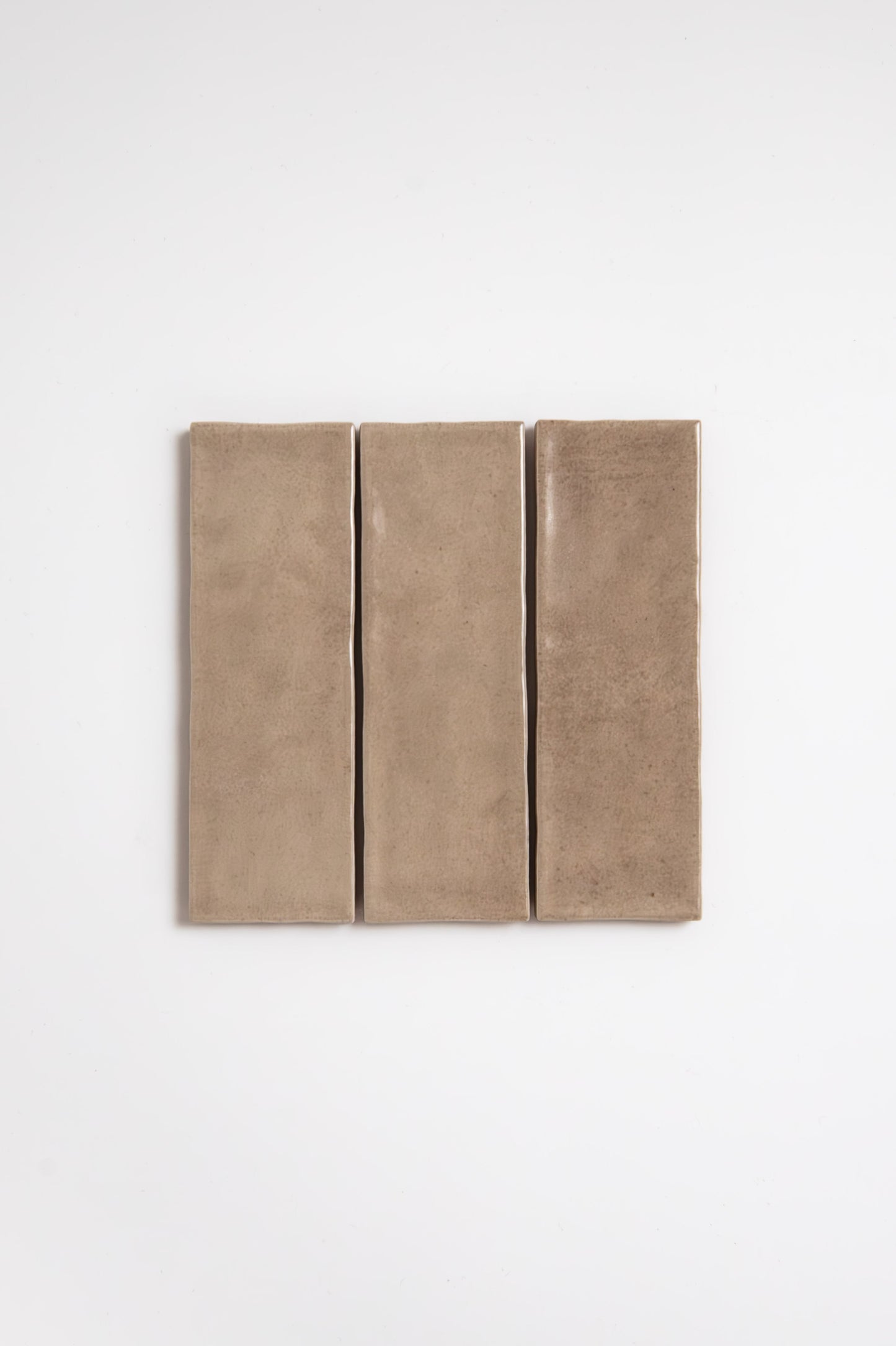 Three Castlegate Brown ceramic tile samples by Cottage Ivy arranged vertically on a plain white background.