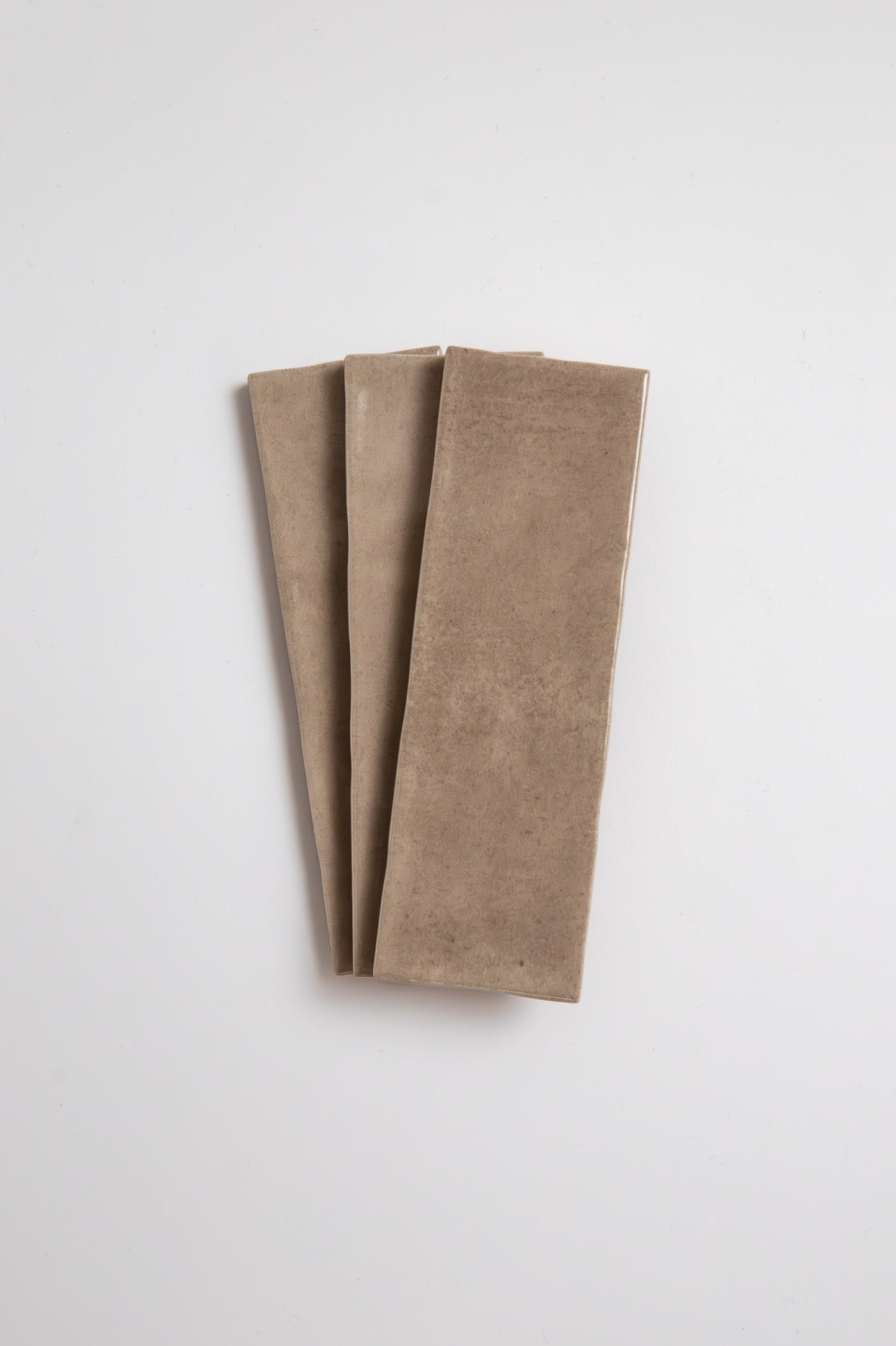 A rectangular Castlegate Brown tile by New York Cement Tile lies flat on a white background.