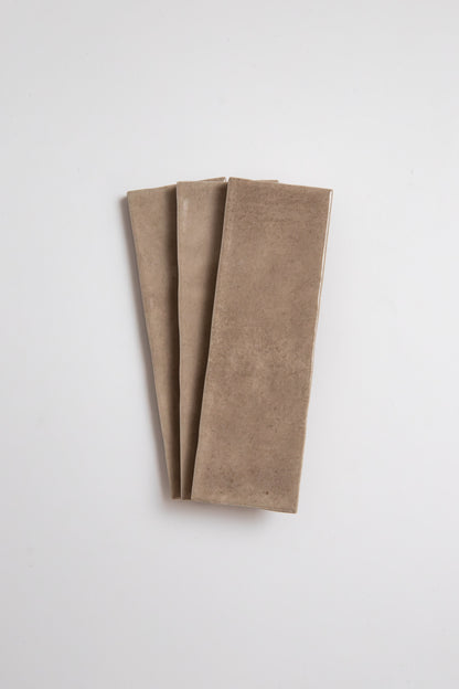 A rectangular Castlegate Brown tile by New York Cement Tile lies flat on a white background.