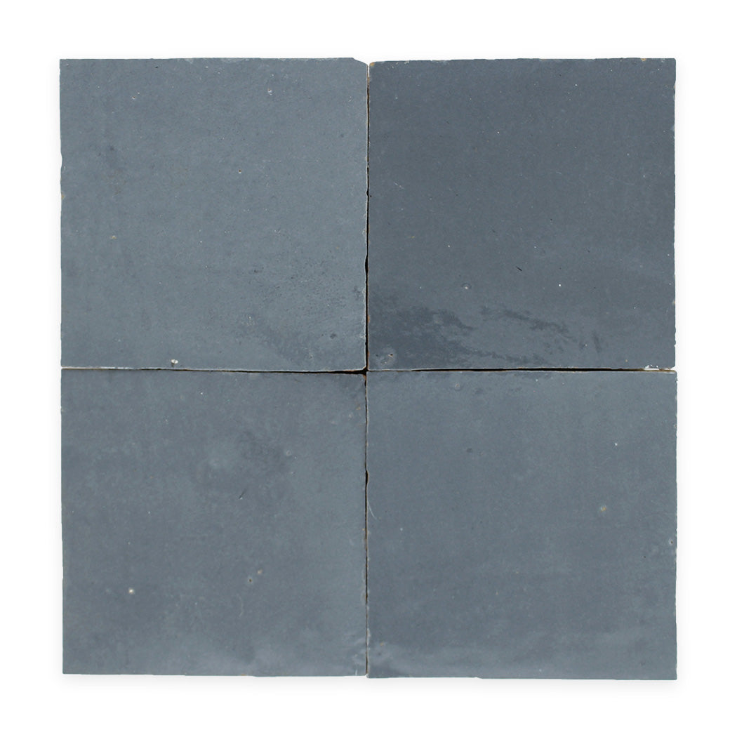 Four square, dark gray ceramic tiles arranged in a two-by-two grid on a white background.
