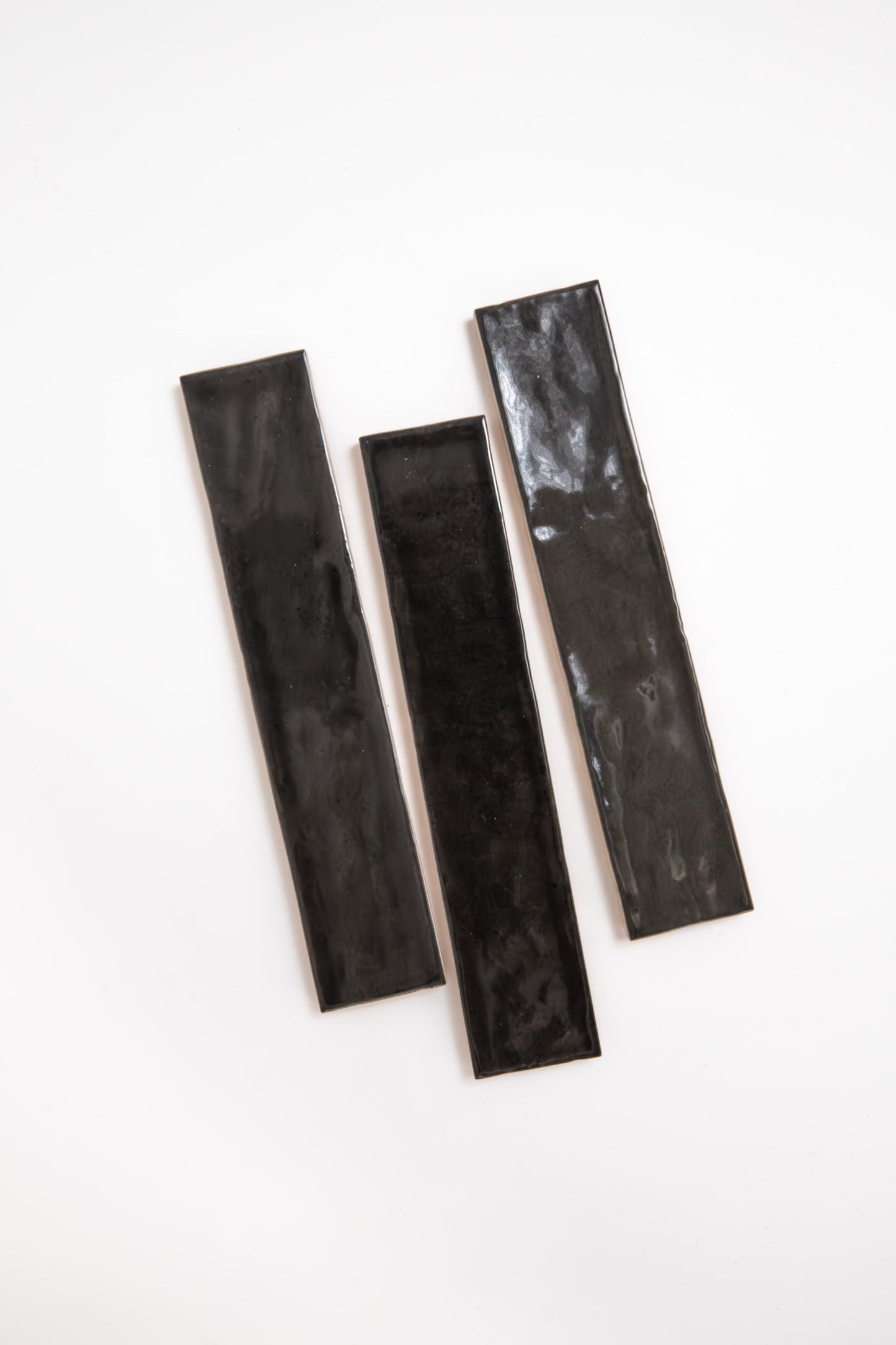 Three Cobbled Graphite tiles by Cottage Ivy are arranged parallel on a plain white background.