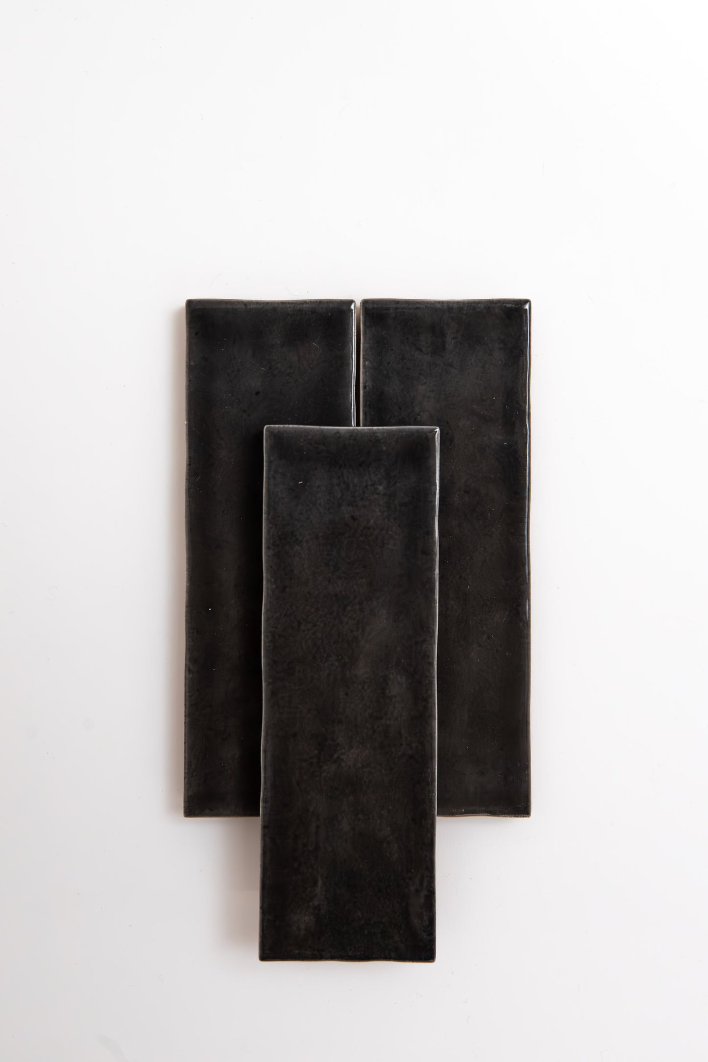 Three Cobbled Graphite tiles by Cottage Ivy overlap on a plain white background.