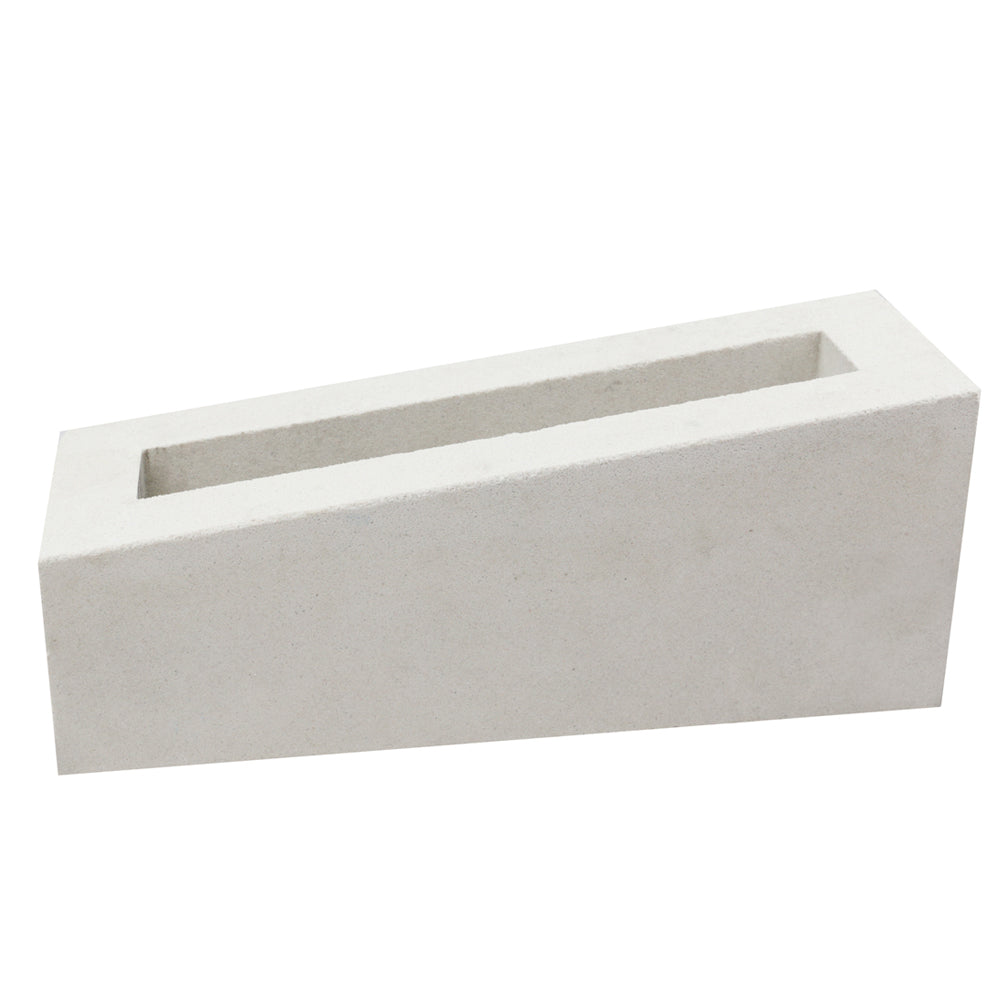 The Corsi Sample by New York Cement Tile is a white, rectangular breeze block with one slanted side on a plain background.