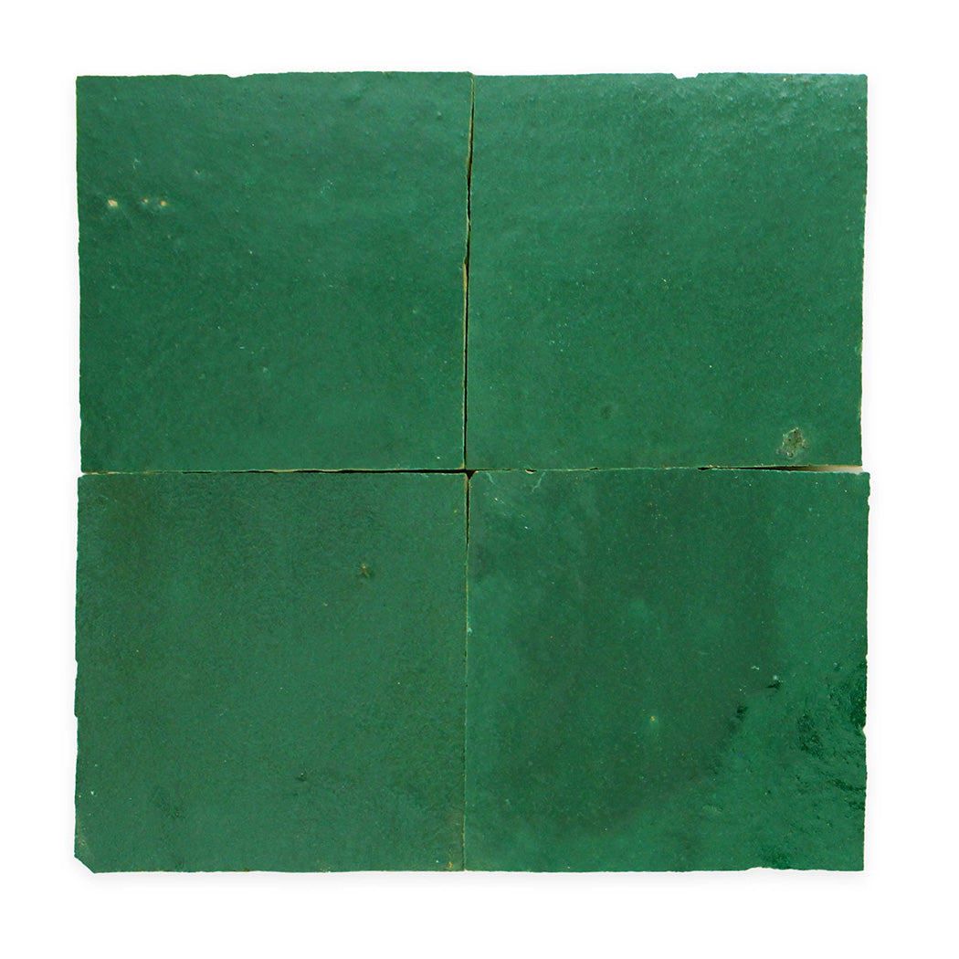 Four square, glossy green ceramic tiles are arranged in a grid against a white background.