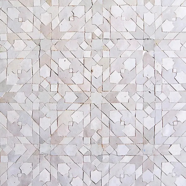 Light-colored geometric tile pattern with intersecting lines and shapes forming a symmetrical, repeating design.