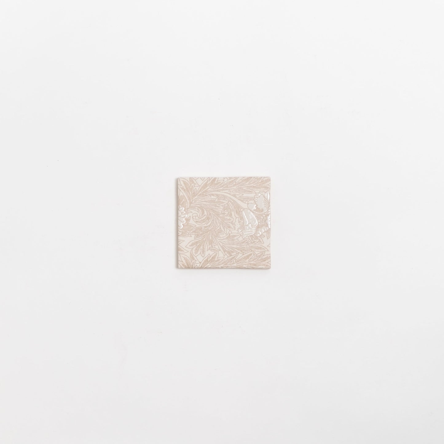 The Grace Deco tile by New York Cement Tile features an ornate floral pattern on a single beige tile against a white background.