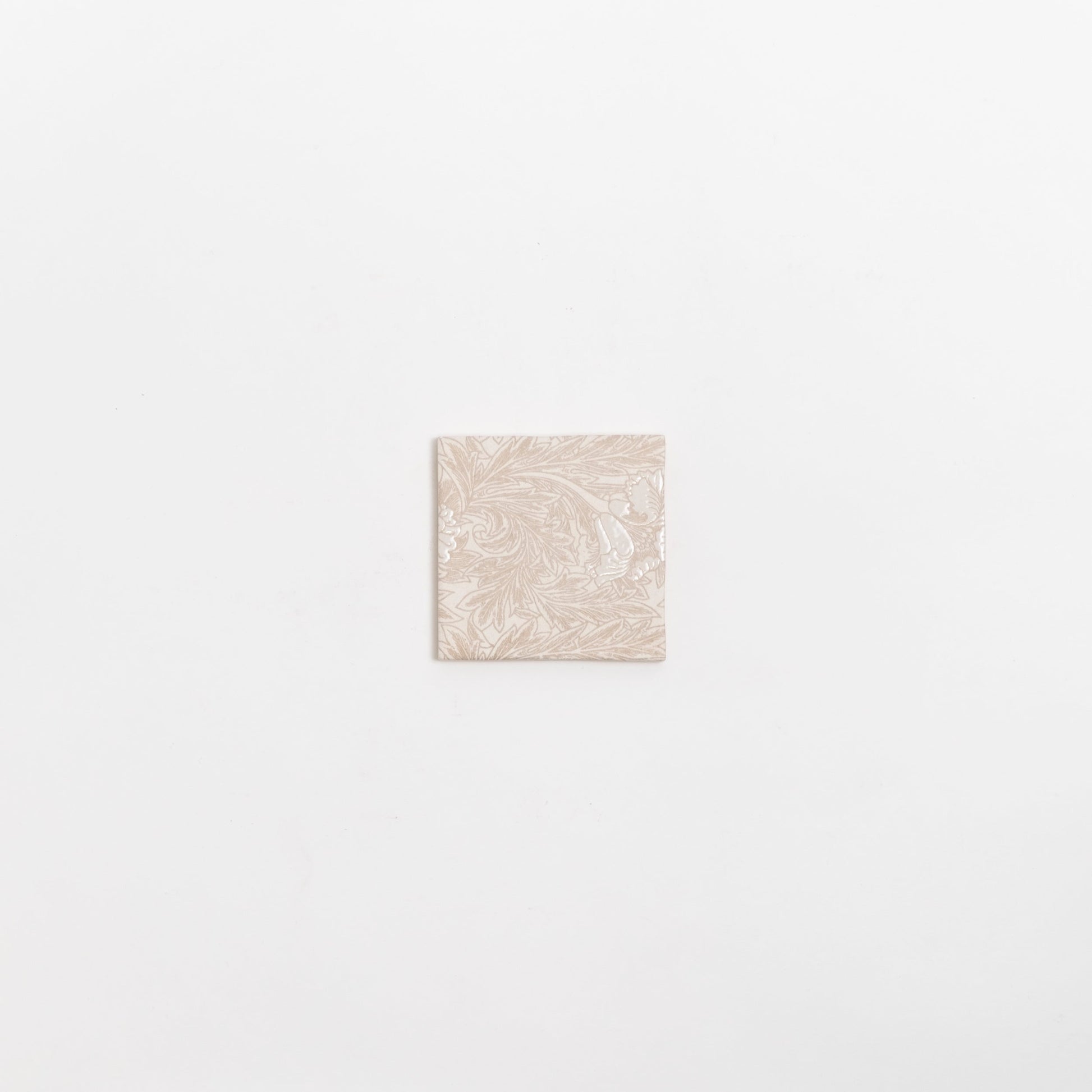 The Grace Deco tile by New York Cement Tile features an ornate floral pattern on a single beige tile against a white background.