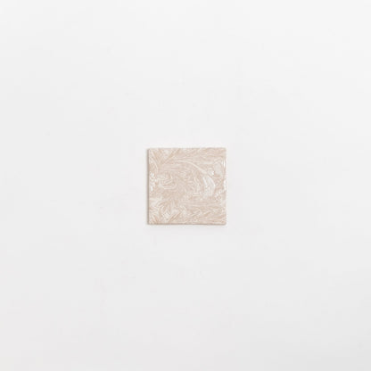 The Grace Deco tile by New York Cement Tile features an ornate floral pattern on a single beige tile against a white background.