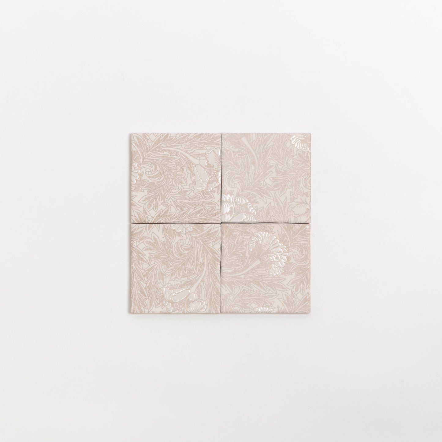 Four Grace Deco tiles by Cottage Ivy, beige ceramic with subtle floral patterns, arranged in a square on white background.