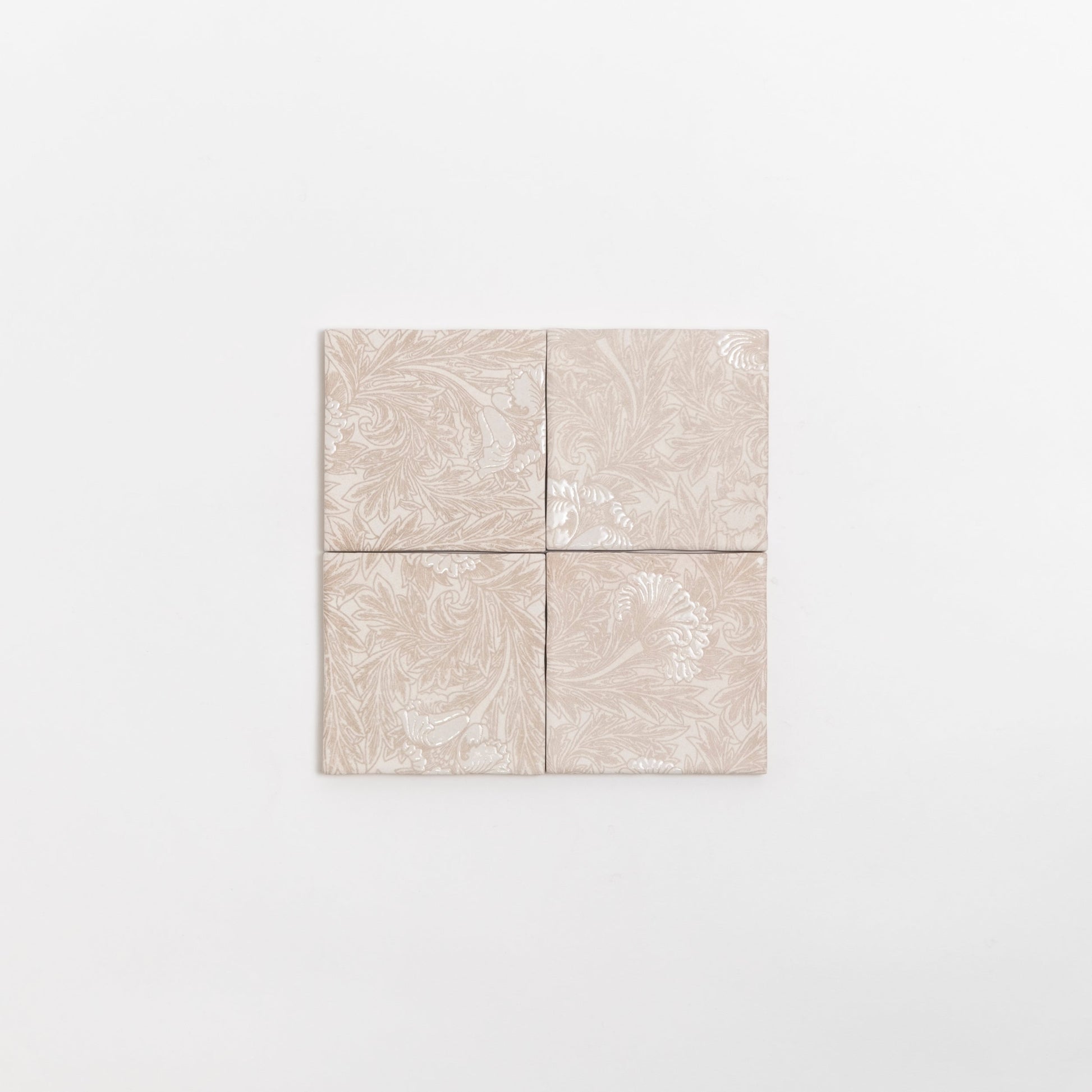 Four Grace Deco tiles by Cottage Ivy, beige ceramic with subtle floral patterns, arranged in a square on white background.