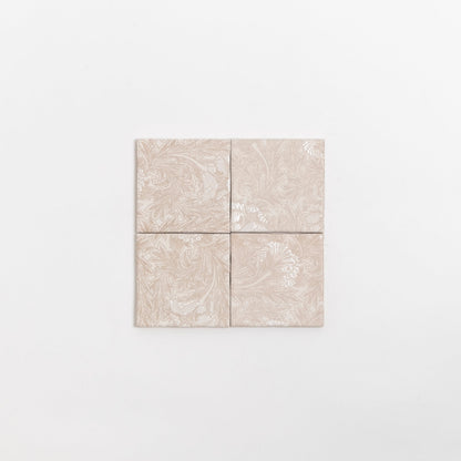 Four Grace Deco tiles by Cottage Ivy, beige ceramic with subtle floral patterns, arranged in a square on white background.