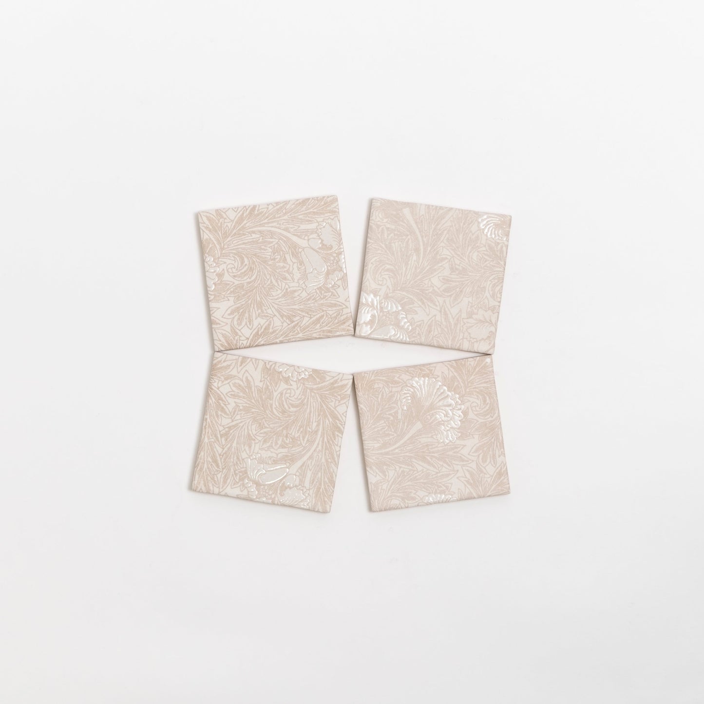 Four Grace Deco tiles by Cottage Ivy, beige with a subtle floral pattern, are arranged in a diamond shape on white.