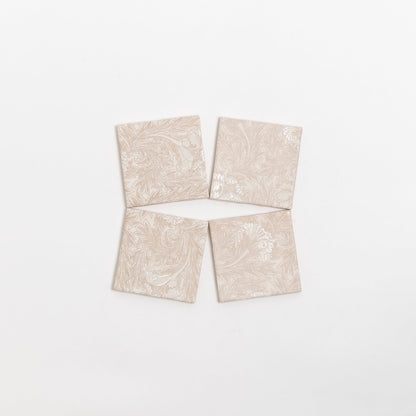 Four Grace Deco tiles by Cottage Ivy, beige with a subtle floral pattern, are arranged in a diamond shape on white.