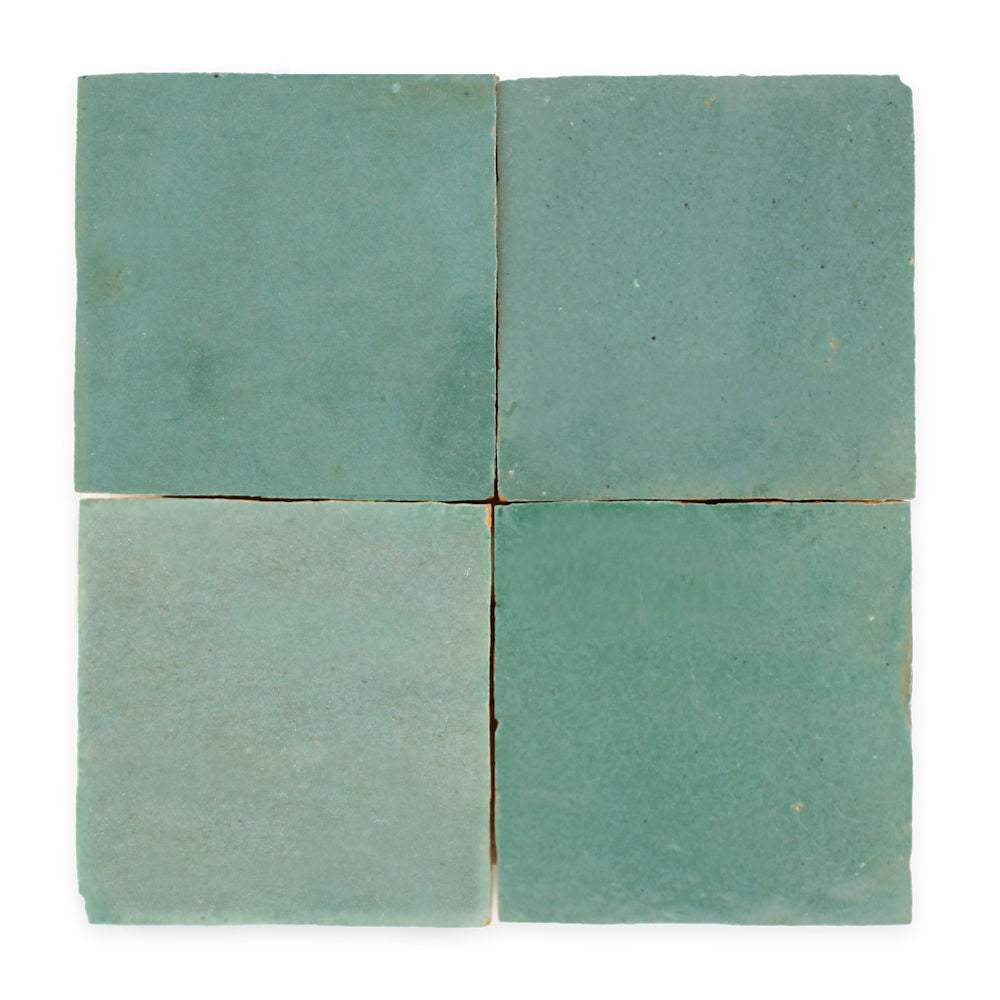 Four square, matte, light teal tiles arranged in a grid on a white background.