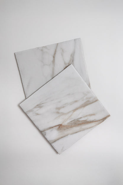 Nine Macchia Vecchia marble tiles by New York Cement Tile, 3x3 grid, light gray and tan veining on white background.